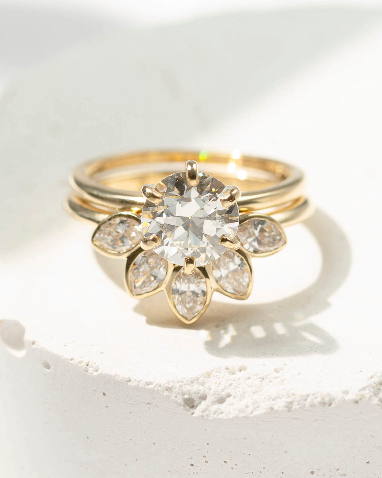 Round diamond engagement ring with marquise diamond petal halo in yellow gold — Sara Gallo Custom Jewelers, Lancaster, PA.