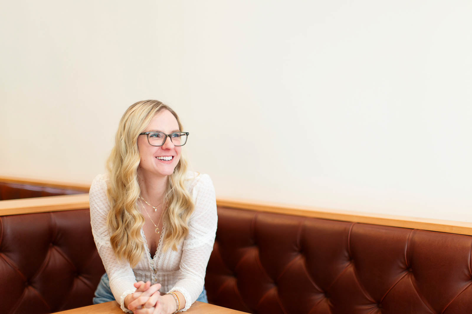 A portrait of Sara Gallo sitting on a brown couch.
