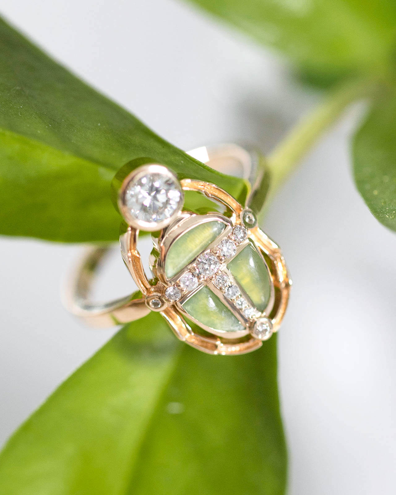 Green jade scarab ring with diamond accents and bezel-set diamond in yellow gold on a leaf — Sara Gallo Custom Jewelers, Lancaster, PA.